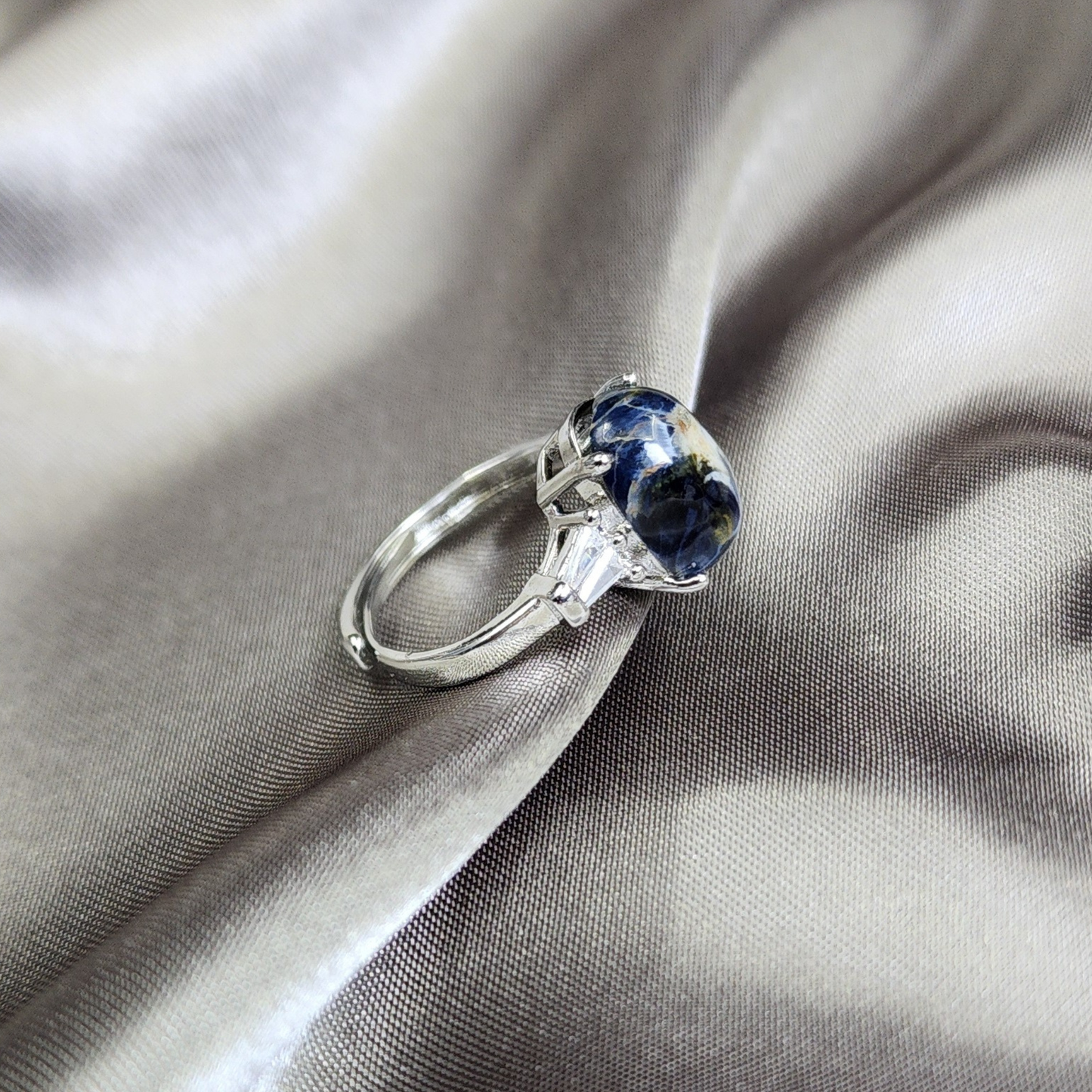 Natural Pietersite adjustable ring with blue-gold storm patterns. Silver-plated design, bold yet elegant statement jewelry | Cincin Pietersite semula jadi boleh laras dengan corak ribut biru keemasan. Reka bentuk bersadur perak, elegan dan moden.