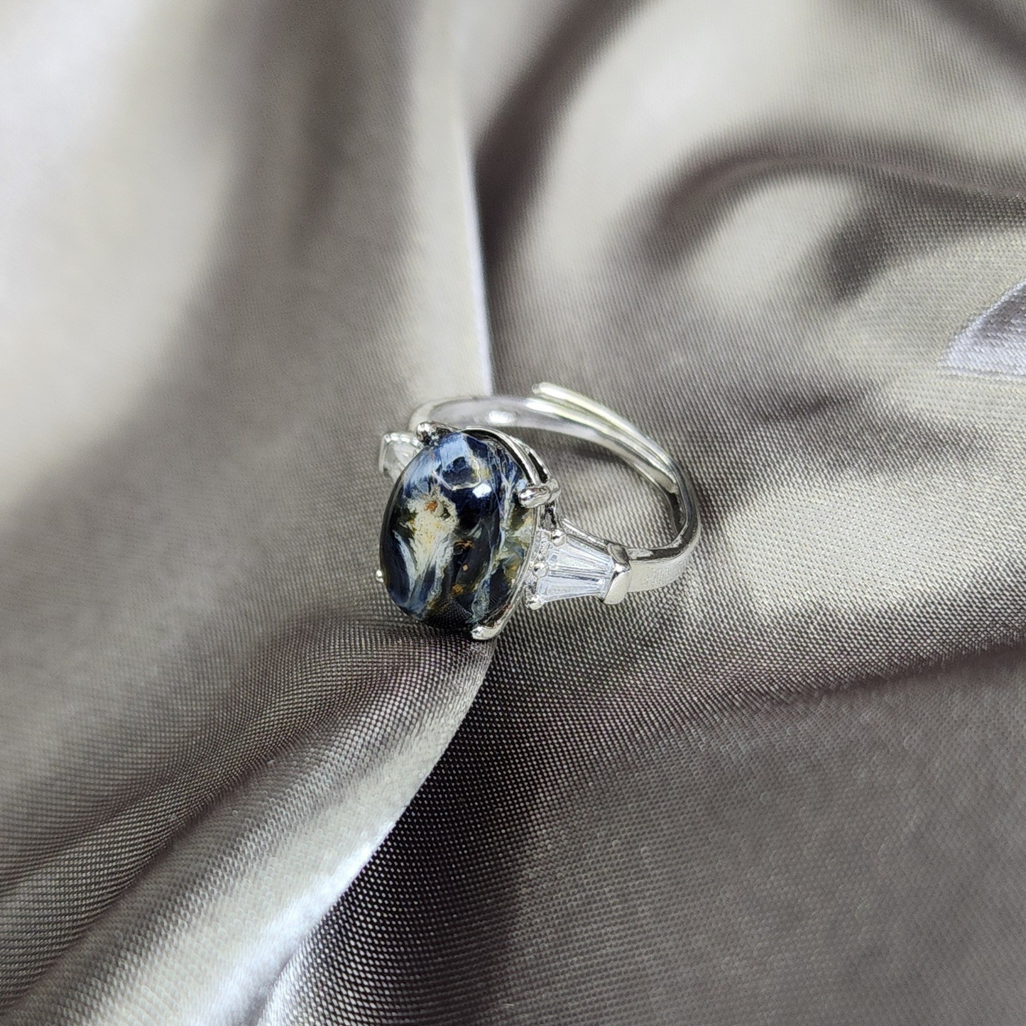 Natural Pietersite adjustable ring with blue-gold storm patterns. Silver-plated design, bold yet elegant statement jewelry | Cincin Pietersite semula jadi boleh laras dengan corak ribut biru keemasan. Reka bentuk bersadur perak, elegan dan moden.