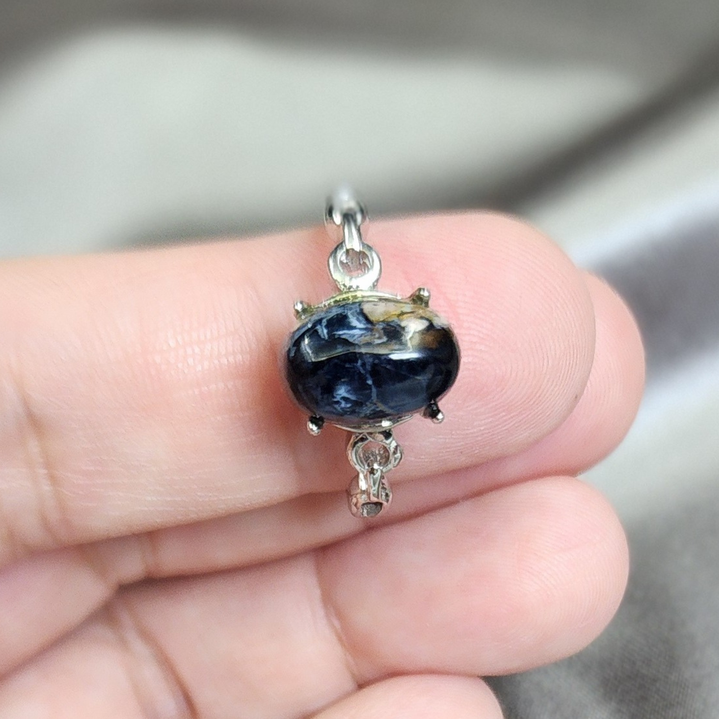 Natural Pietersite adjustable ring with blue-gold storm patterns. Silver-plated design, bold yet elegant statement jewelry | Cincin Pietersite semula jadi boleh laras dengan corak ribut biru keemasan. Reka bentuk bersadur perak, elegan dan moden.