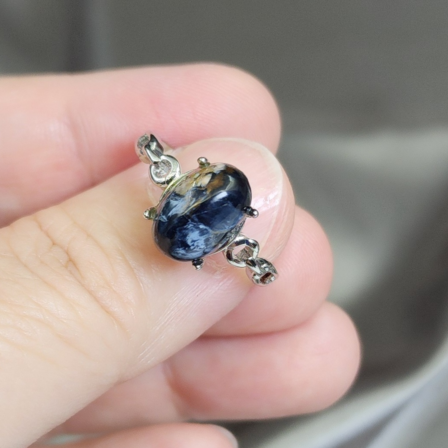 Natural Pietersite adjustable ring with blue-gold storm patterns. Silver-plated design, bold yet elegant statement jewelry | Cincin Pietersite semula jadi boleh laras dengan corak ribut biru keemasan. Reka bentuk bersadur perak, elegan dan moden.